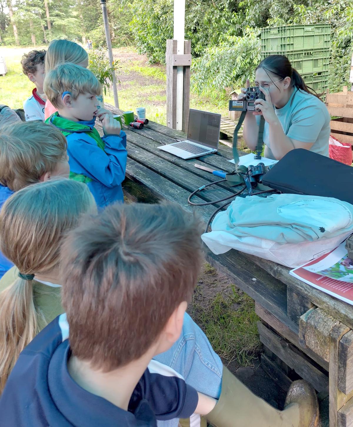 Een groep kinderen krijgt uitleg over het gebruik van een wildcamera (bron: Werkgroep Kleine Marterachtigen)